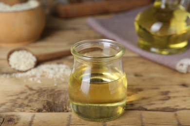 Photo of Fresh sesame oil and seeds on wooden rustic table