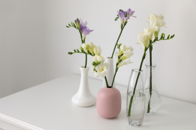 Beautiful spring freesia flowers on white table in room