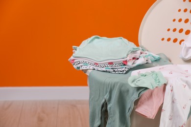 Laundry basket with baby clothes indoors, closeup, Space for text