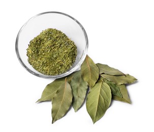 Whole and ground aromatic bay leaves on white background, top view