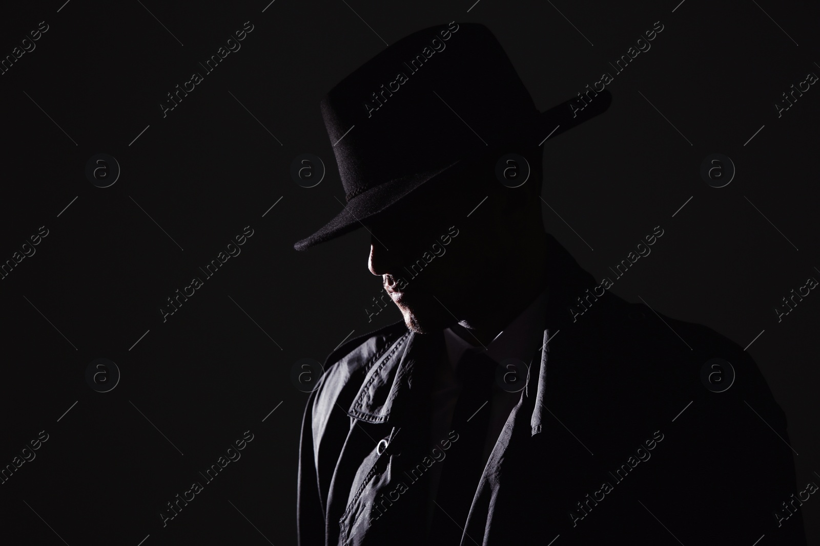 Photo of Old fashioned detective in hat on dark background