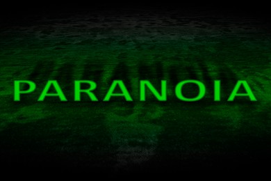 Image of Mental disorder. Bright word Paranoia on dark surface, toned in green