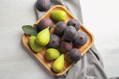 Photo of Plate with assorted ripe figs on light background, top view