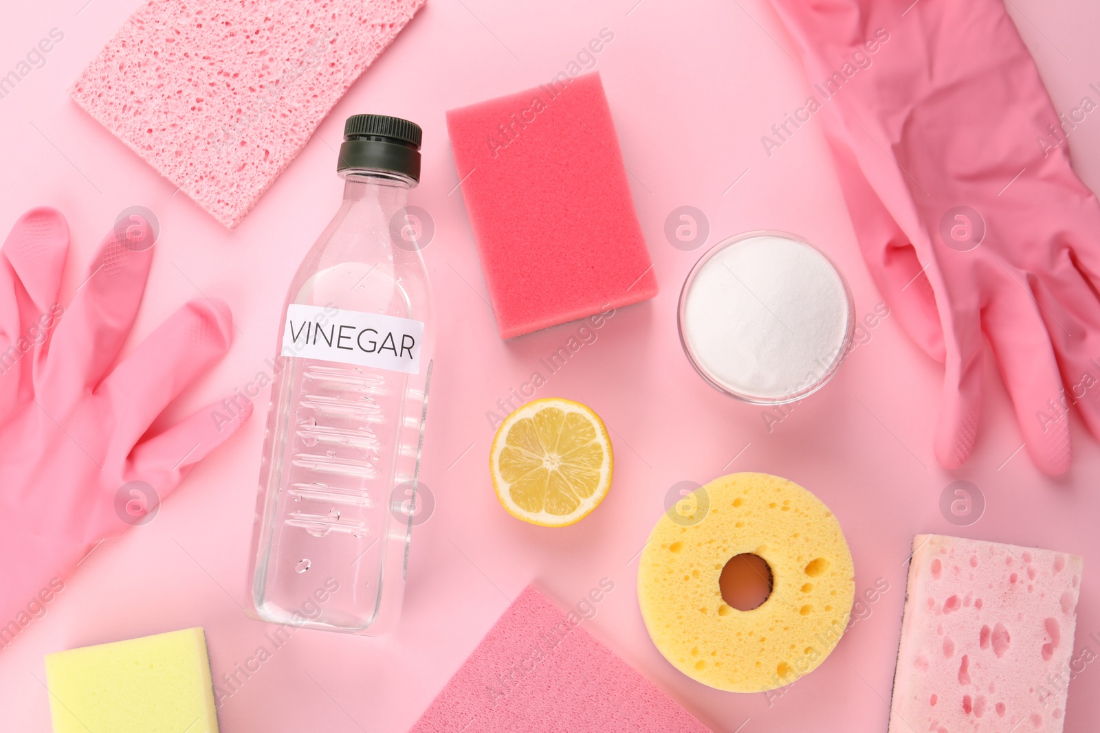 Photo of Eco friendly natural cleaners. Flat lay composition with bottle of vinegar on pink background