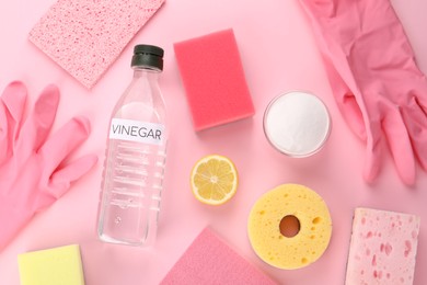 Eco friendly natural cleaners. Flat lay composition with bottle of vinegar on pink background