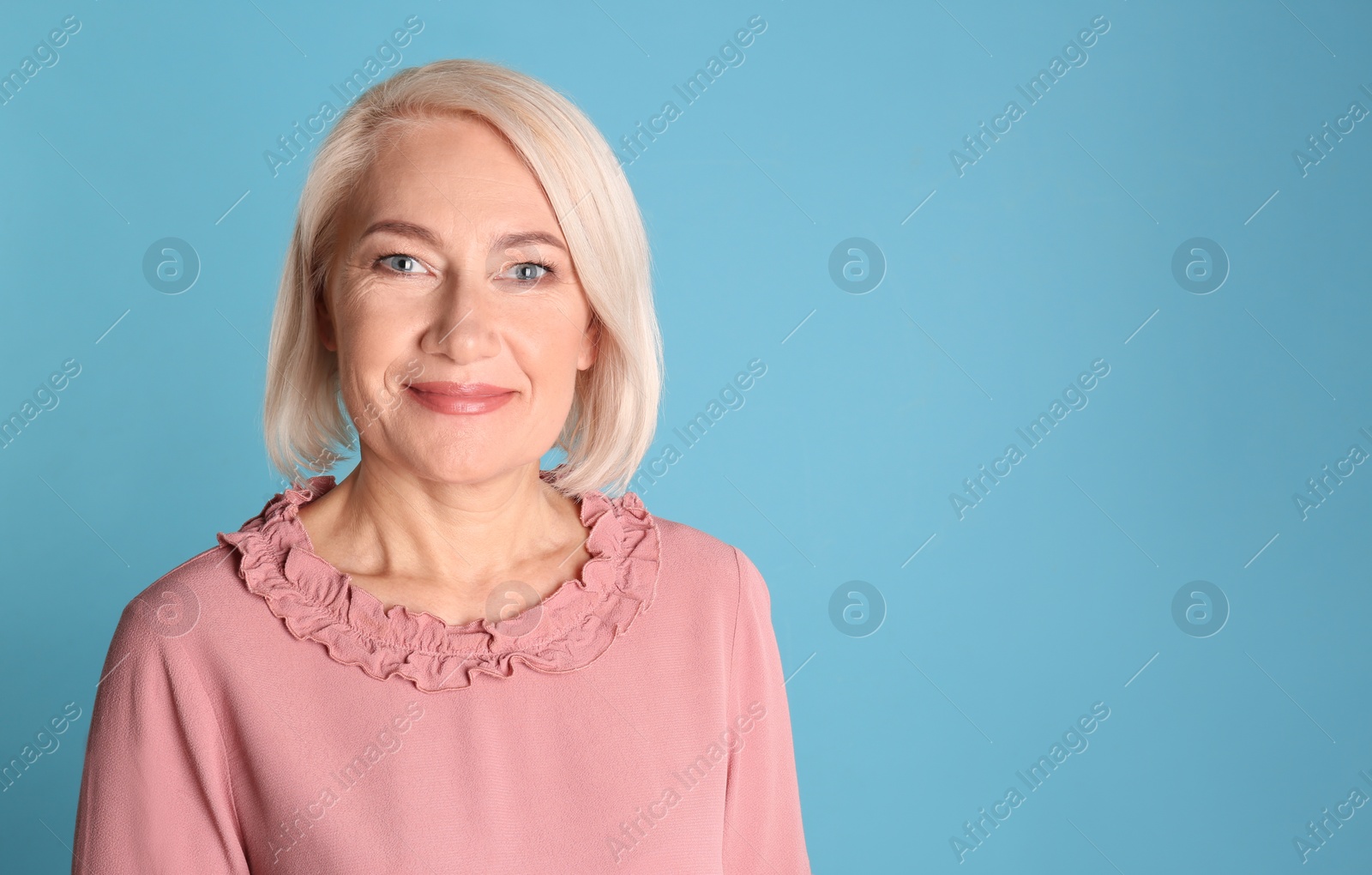 Photo of Portrait of charming mature woman with healthy beautiful face skin and natural makeup on blue background, space for text