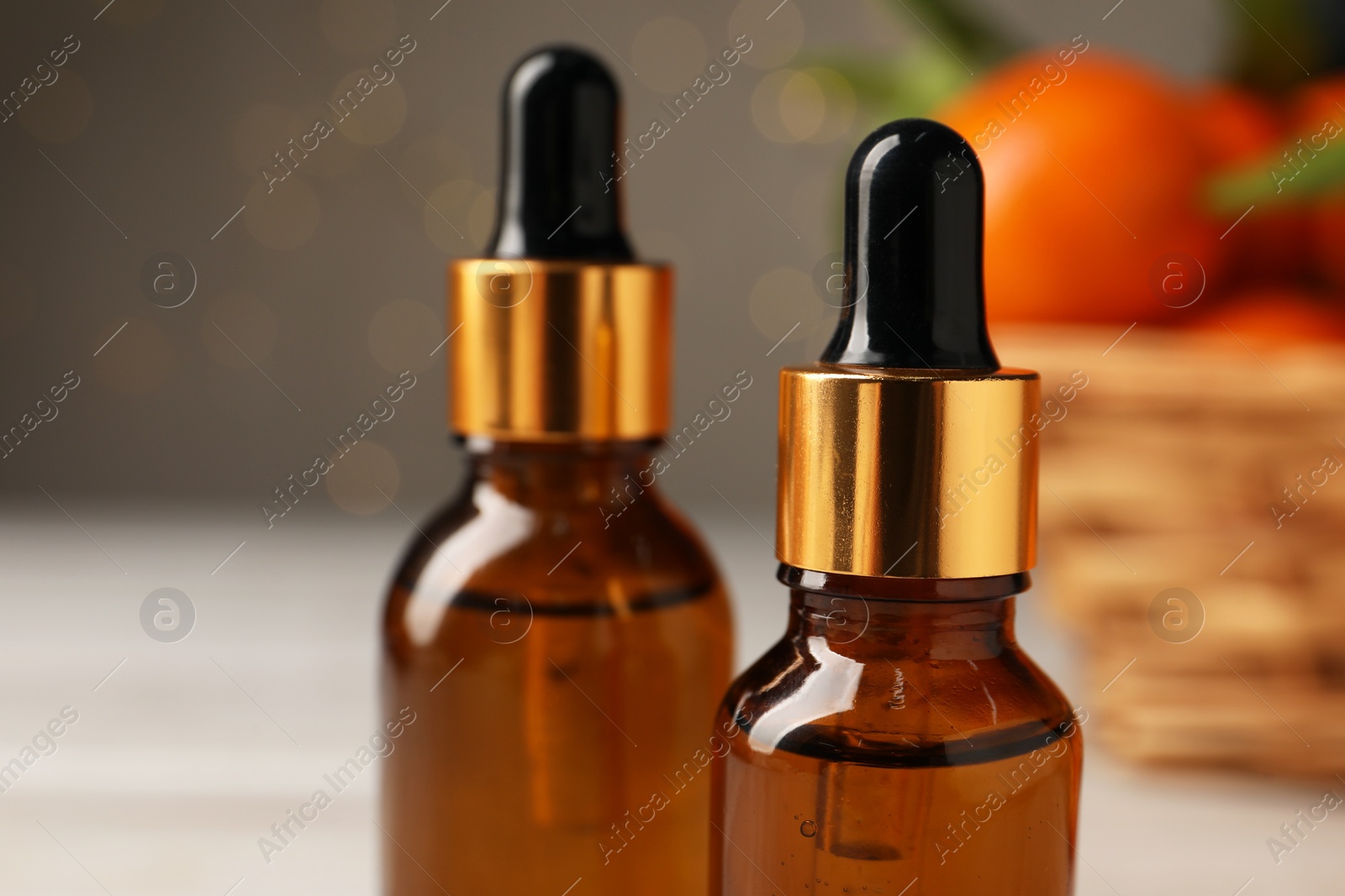 Photo of Bottle of tangerine essential oil on blurred background, closeup