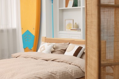 SUP board, bed and furniture in room. Interior design