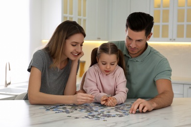 Photo of Happy family playing with puzzles at home