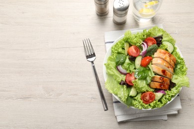 Delicious salad with chicken and vegetables served on wooden table, top view. Space for text