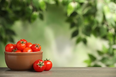 Photo of Wooden bowl with fresh tomatoes on blurred background. Space for text