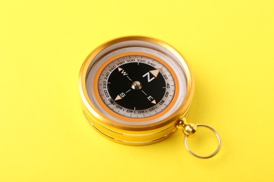 Photo of One compass on yellow background. Navigation equipment
