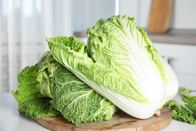 Photo of Fresh ripe Chinese cabbages on white table, closeup
