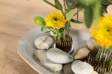 Composition with beautiful yellow flowers and stones on table, closeup