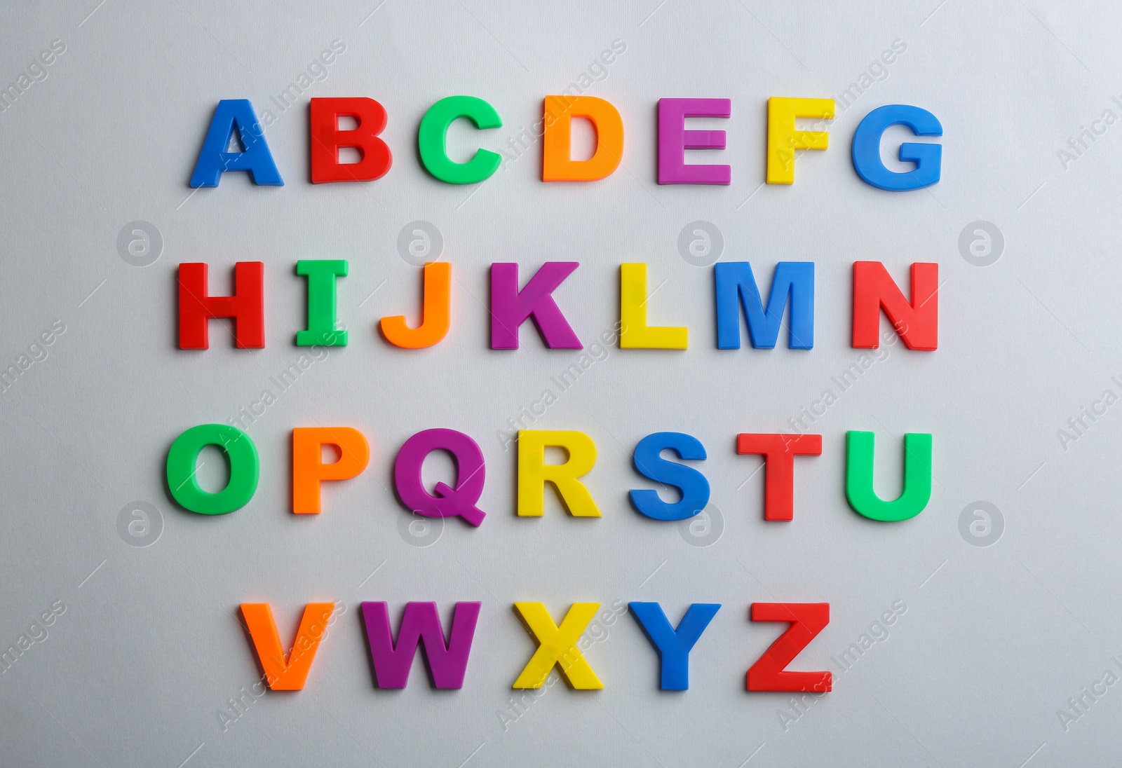 Photo of Plastic magnetic letters on grey background, flat lay. Alphabetical order