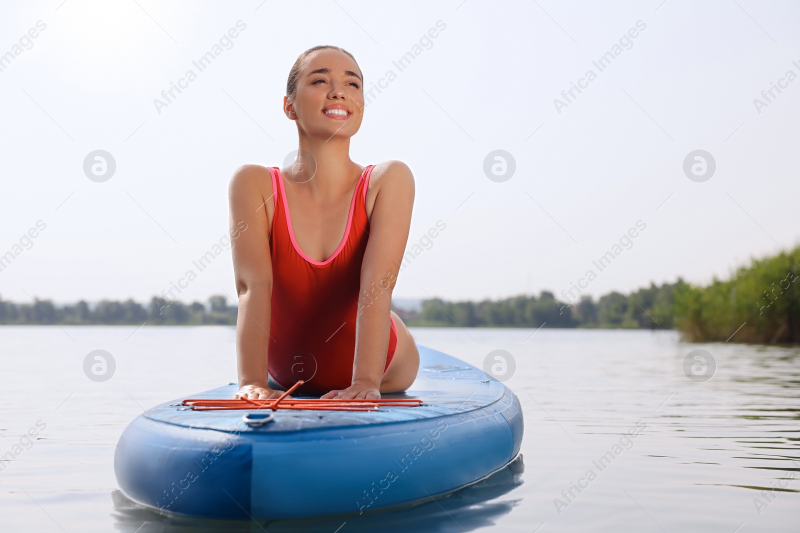 Photo of Woman practicing yoga on light blue SUP board on river, space for text