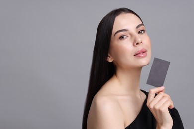 Photo of Woman holding blank business card on grey background. Space for text