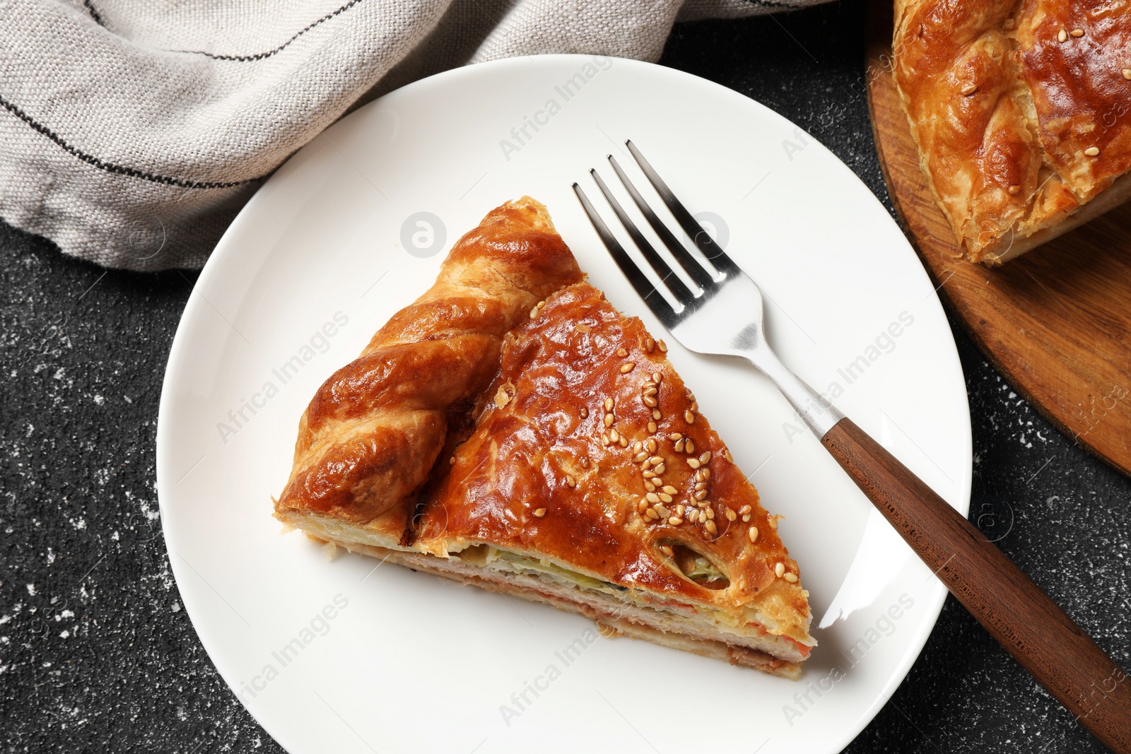 Photo of Tasty homemade pie with filling served on black table, flat lay