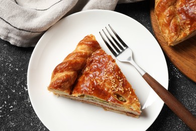 Tasty homemade pie with filling served on black table, flat lay