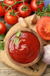 Photo of Tasty ketchup, fresh tomatoes, parsley and spices on wooden table, flat lay