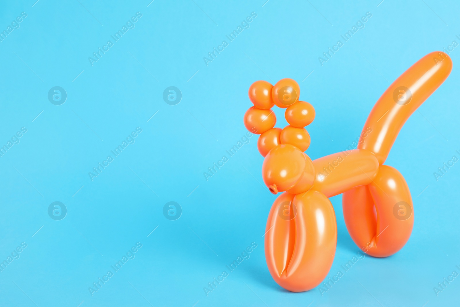 Photo of Animal figure made of modelling balloon on color background. Space for text