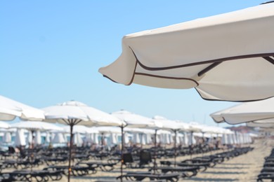 Beautiful white beach umbrella at resort, closeup. Space for text