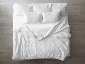 Photo of Comfortable bed with soft pillows indoors, top view