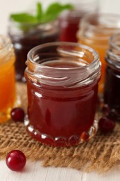 Photo of Jar of sweet jam on table, closeup