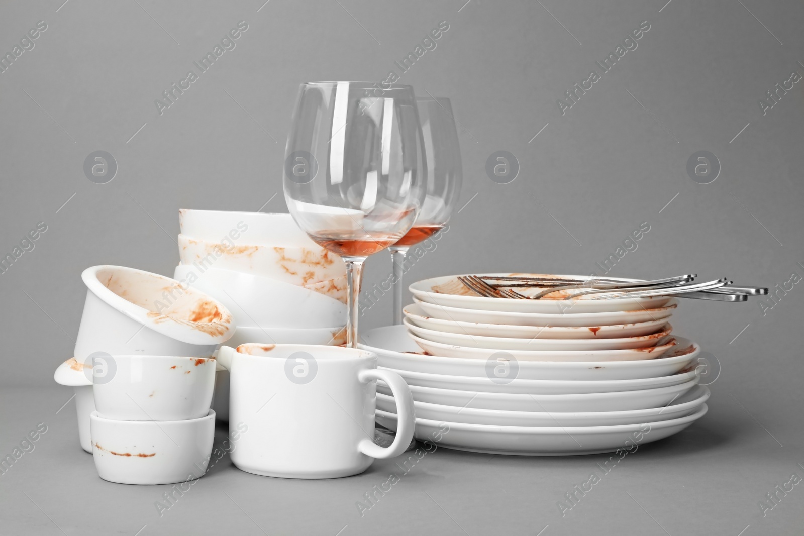 Photo of Set of dirty dishes on grey background