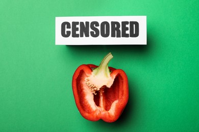 Photo of Card with word Censored and half of red bell pepper on green background, flat lay