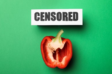 Card with word Censored and half of red bell pepper on green background, flat lay