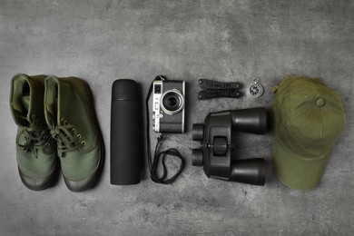 Photo of Set of traveler's equipment on grey table, flat lay