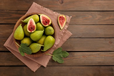 Photo of Cut and whole green figs on wooden table, flat lay. Space for text