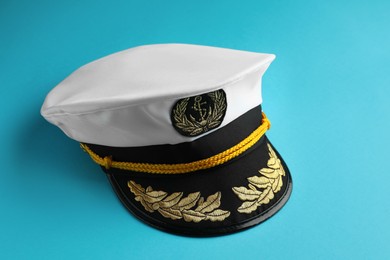 Photo of Peaked cap with accessories on light blue background