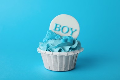 Photo of Baby shower cupcake with Boy topper on light blue background