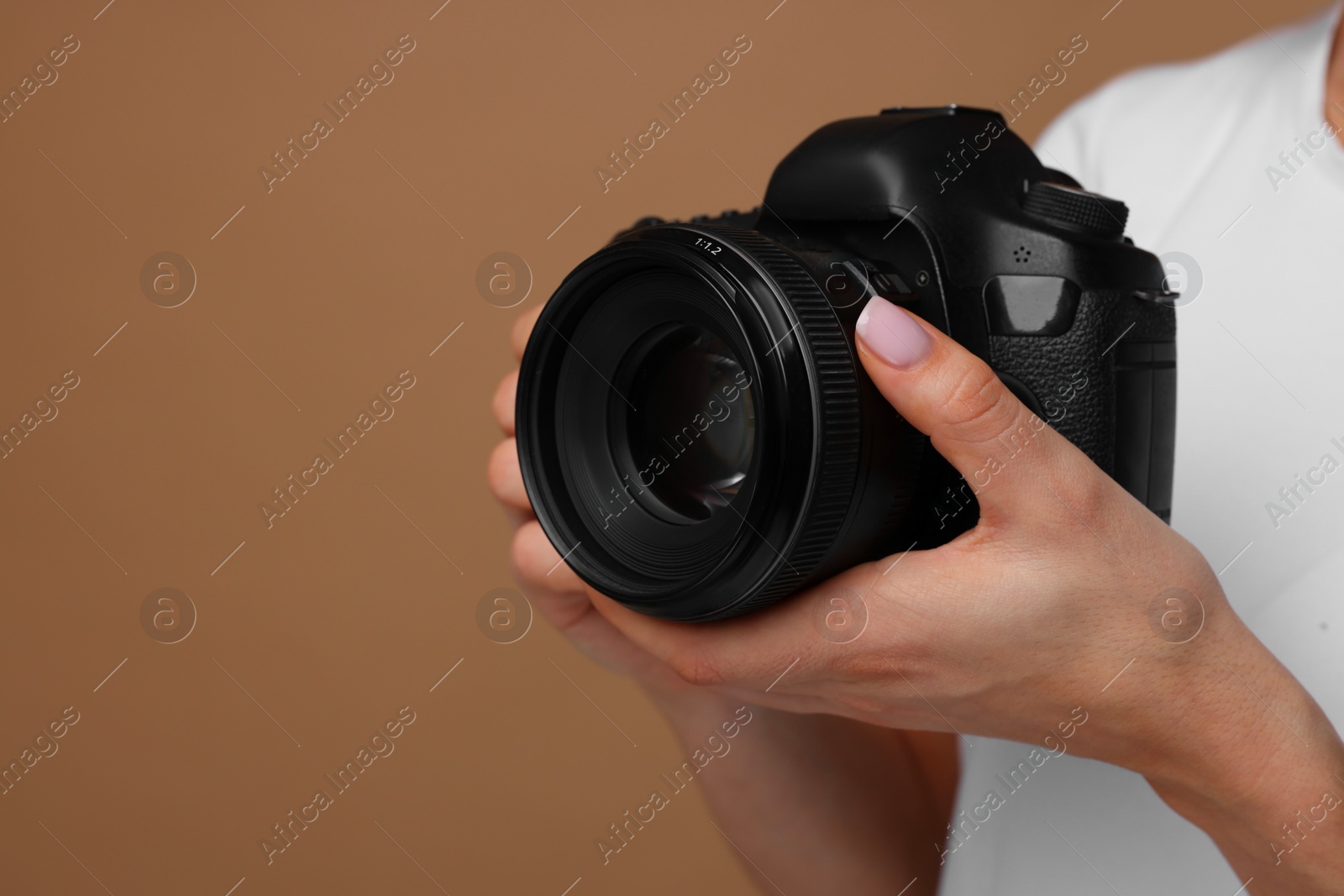 Photo of Photographer with camera on brown background, closeup. Space for text