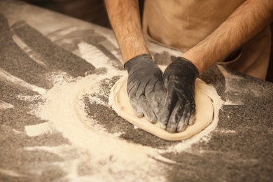 Photo of Man making pizza at table, closeup view