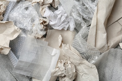 Photo of Pile of paper and plastic garbage as background, top view. Recycling problem