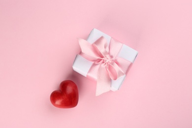 Beautiful gift box and red heart on pink background, flat lay. Valentine's day celebration