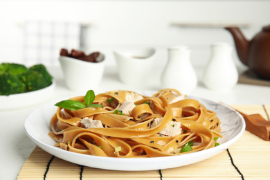 Tasty buckwheat noodles with meat served on kitchen table