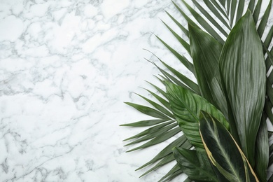 Photo of Flat lay composition with tropical leaves and space for text on marble background