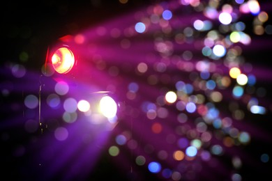 Bright spotlights and beams of light in night club, bokeh effect