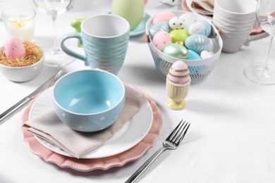 Photo of Festive table setting with painted eggs. Easter celebration