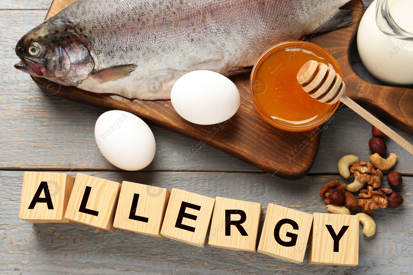 Image of Food allergy. Different fresh products and cubes on grey wooden table, flat lay