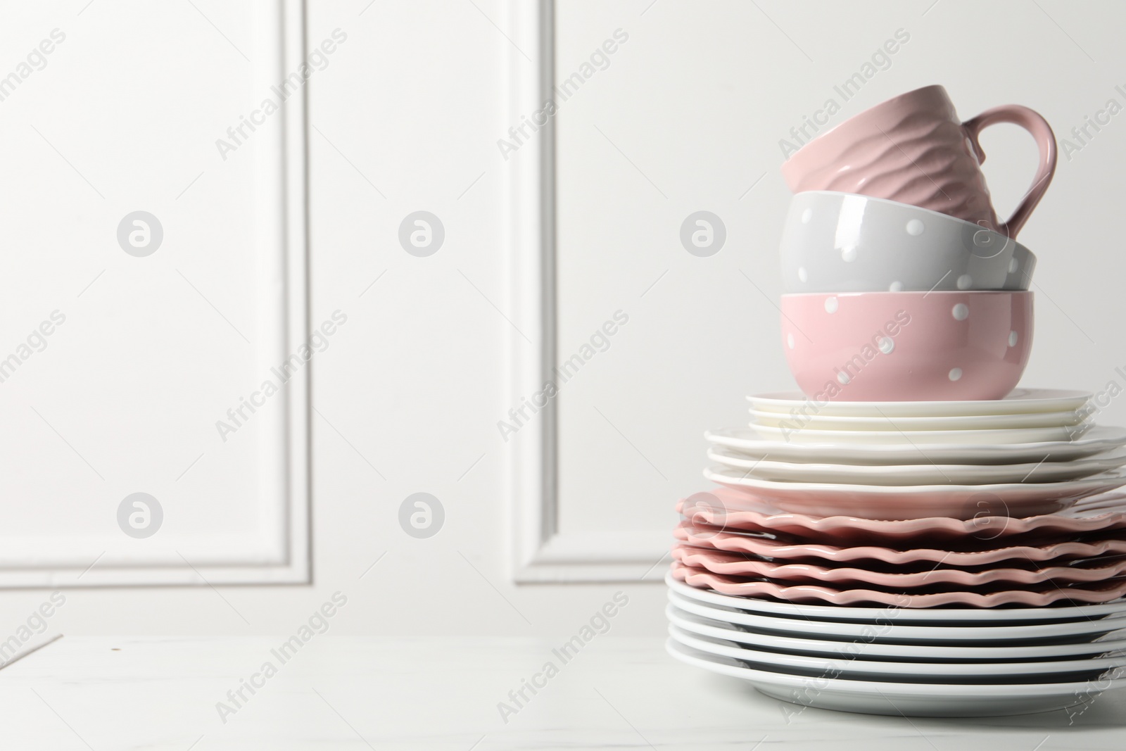 Beautiful ceramic dishware and cup on white marble table, space for text Photo of Beautiful ceramic dishware and cup on white marble table, space for text