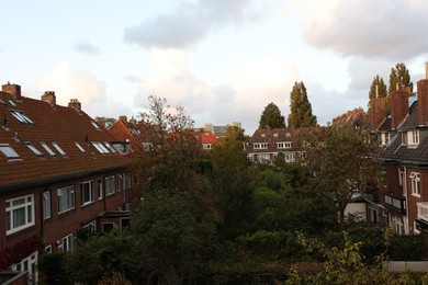 Photo of Beautiful buildings and trees in city under sky with clouds
