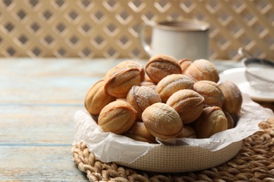 Photo of Bowl of delicious nut shaped cookies on grey wooden table. Space for text