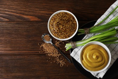 Photo of Delicious whole grain mustard, seeds and fresh green onion on wooden table, flat lay