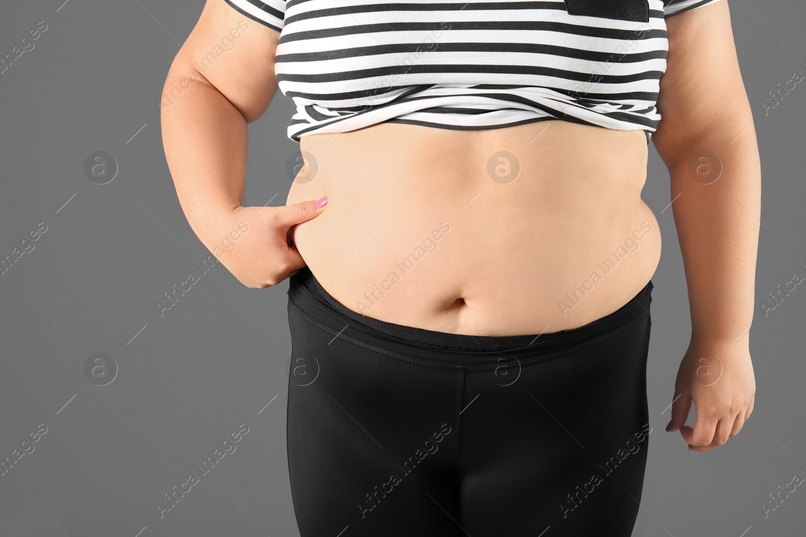 Photo of Overweight woman on gray background, closeup view