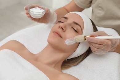 Photo of Young woman during face peeling procedure in salon